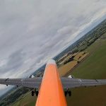 Rear view of Airbus test aircraft with extended wings in flight, showcasing foldable wing concept